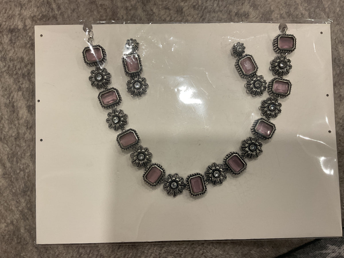 Dusty-pink necklace and earrings with rectangular colored inserts alternating with silver-tone floral links.