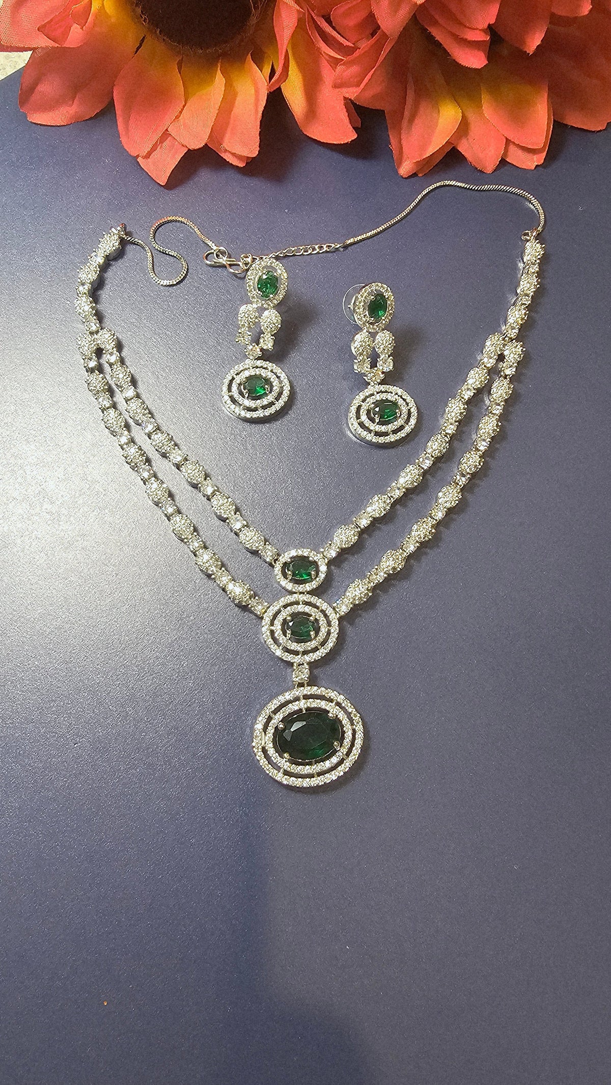two-row design with green stones and two earrings.