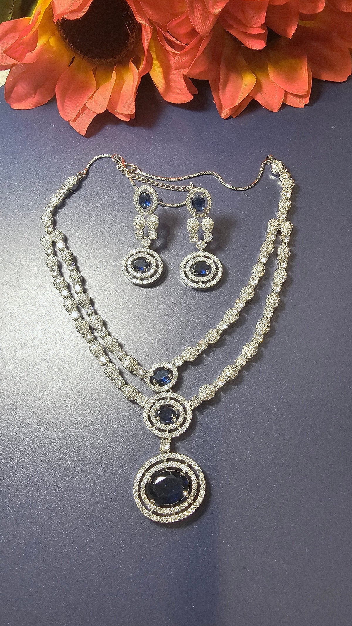 two-row design with blue stones and two earrings.