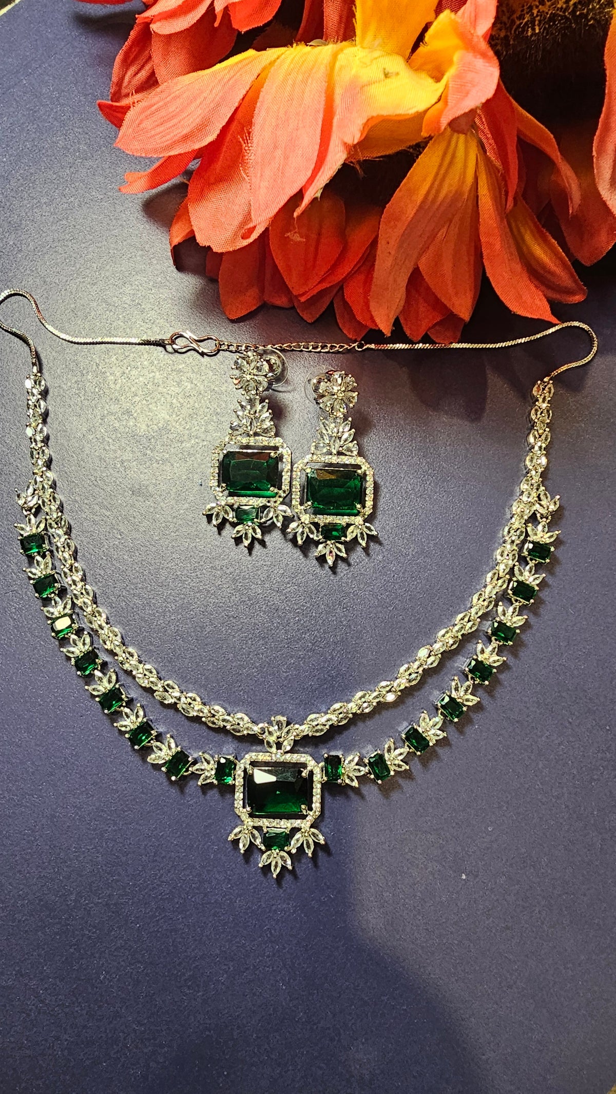 layered necklace design with green rectangular stones and two earrings.
