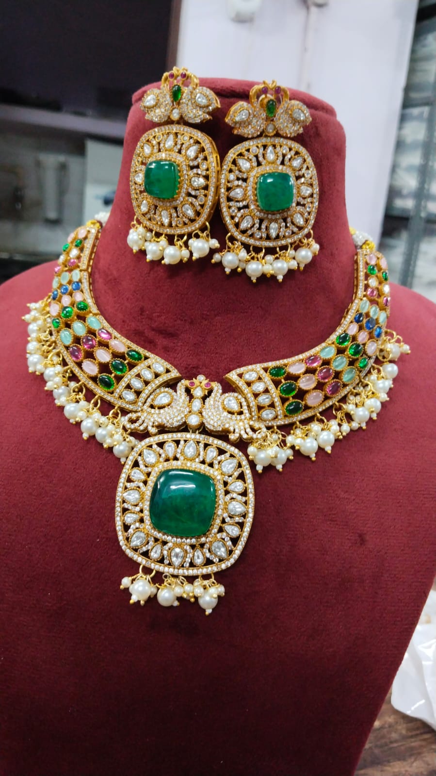 Gold-tone necklace and two earrings; green rounded rectangular center stones, multicolor side accents, white bead fringe and bird motifs.