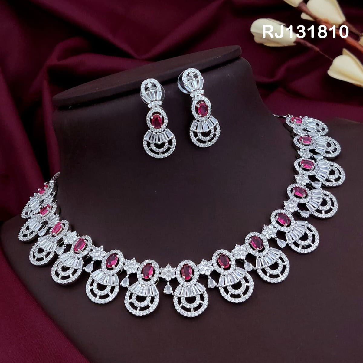 Silver-tone collar necklace with rani pink oval stones and circular fan-like drops.