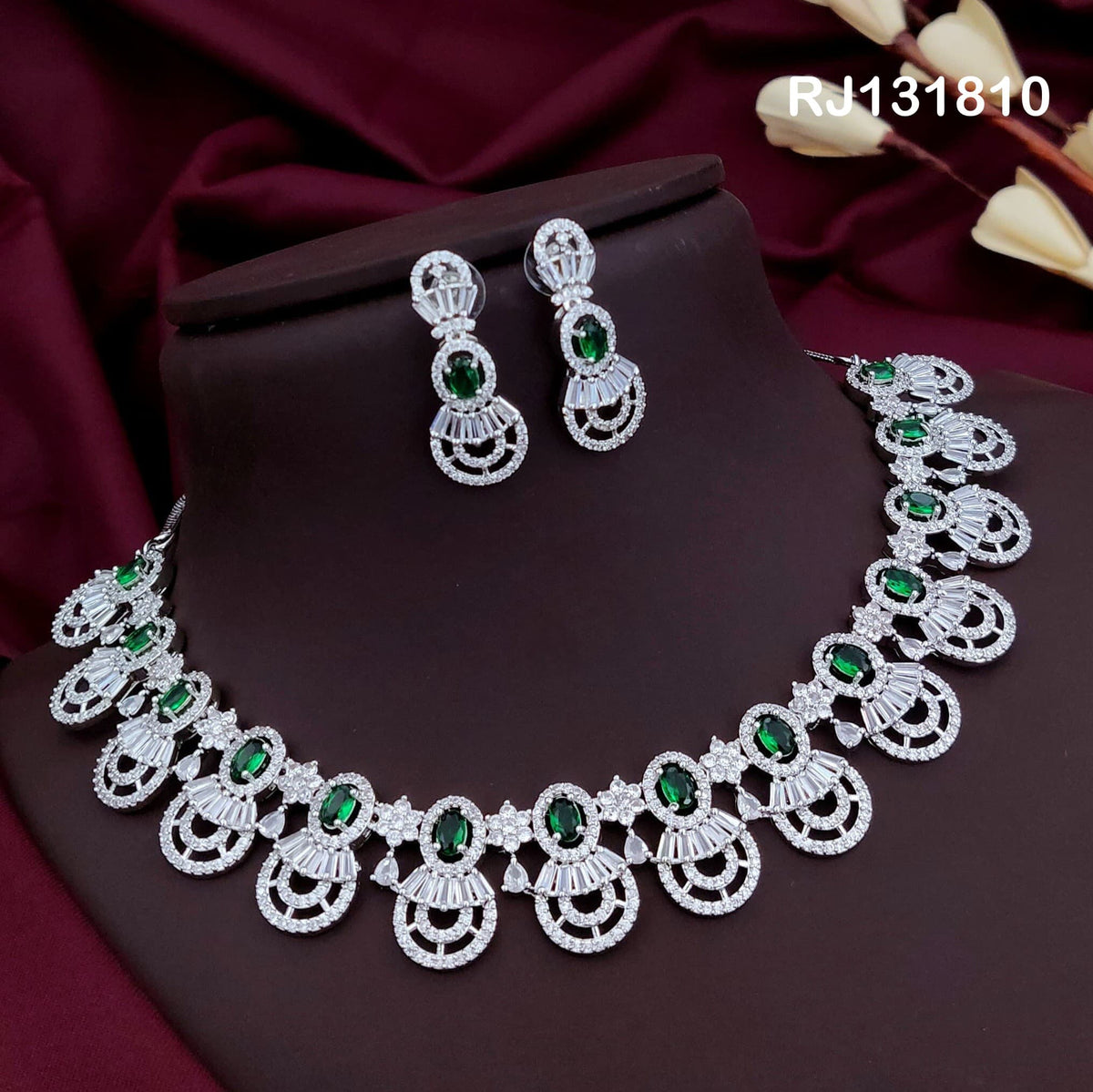 silver-tone collar necklace with fan-like drops with green stones.