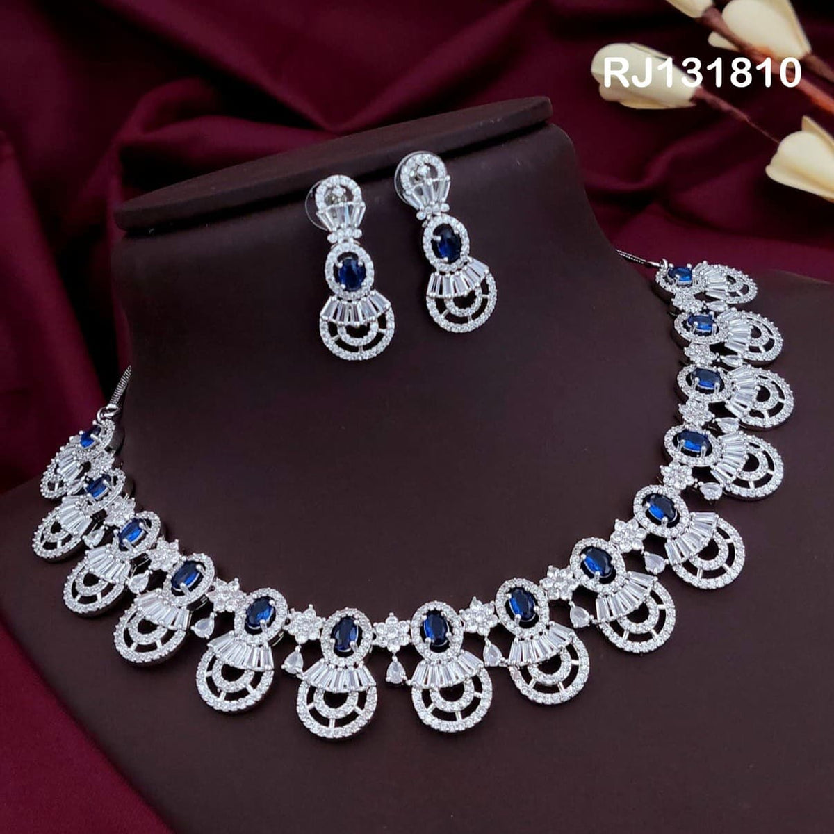 silver-tone collar necklace with fan-like drops with blue stones.