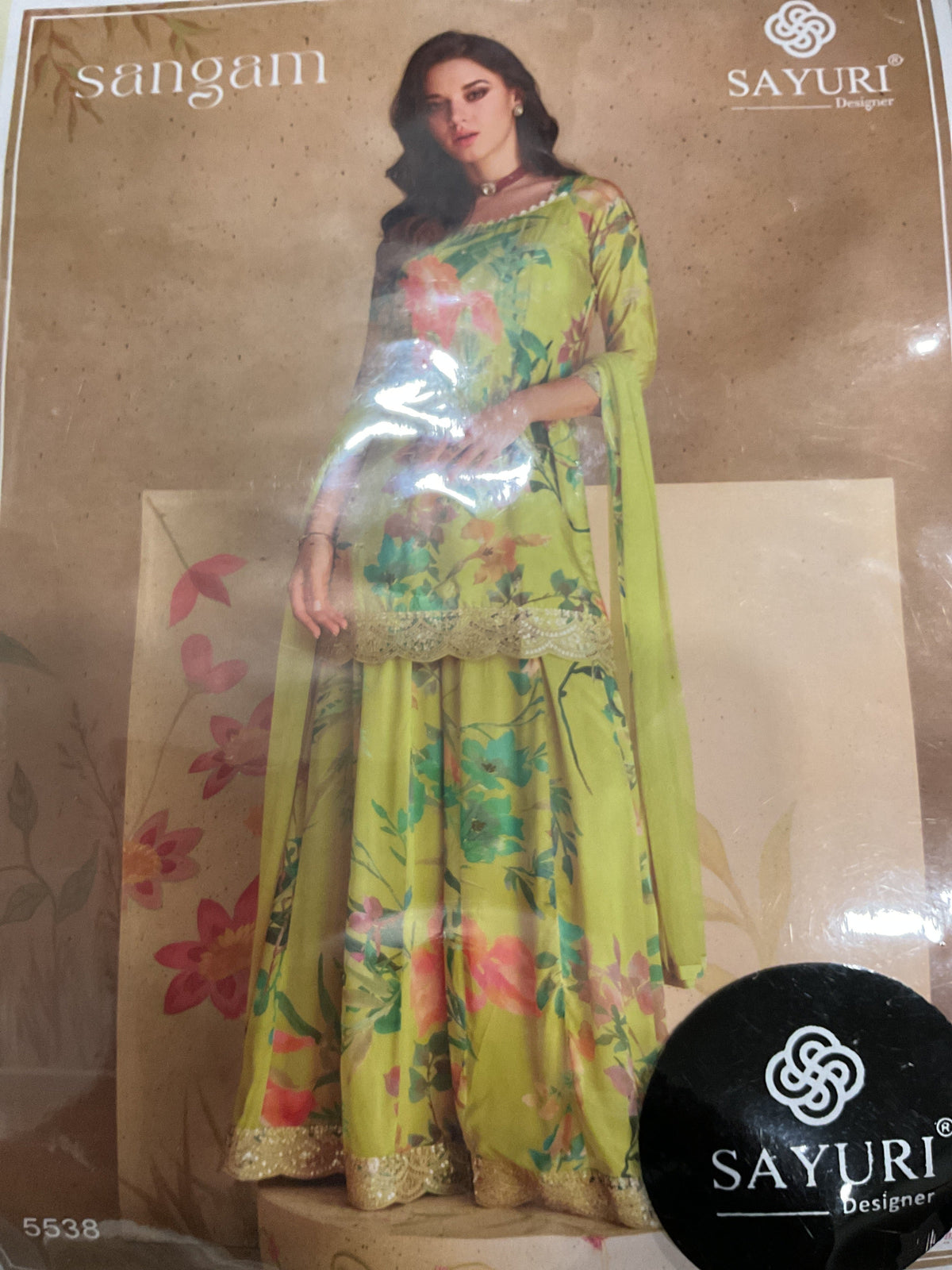 Light green floral tunic, flared trousers and drape photographed through packaging; Sayuri/Sangam branding.