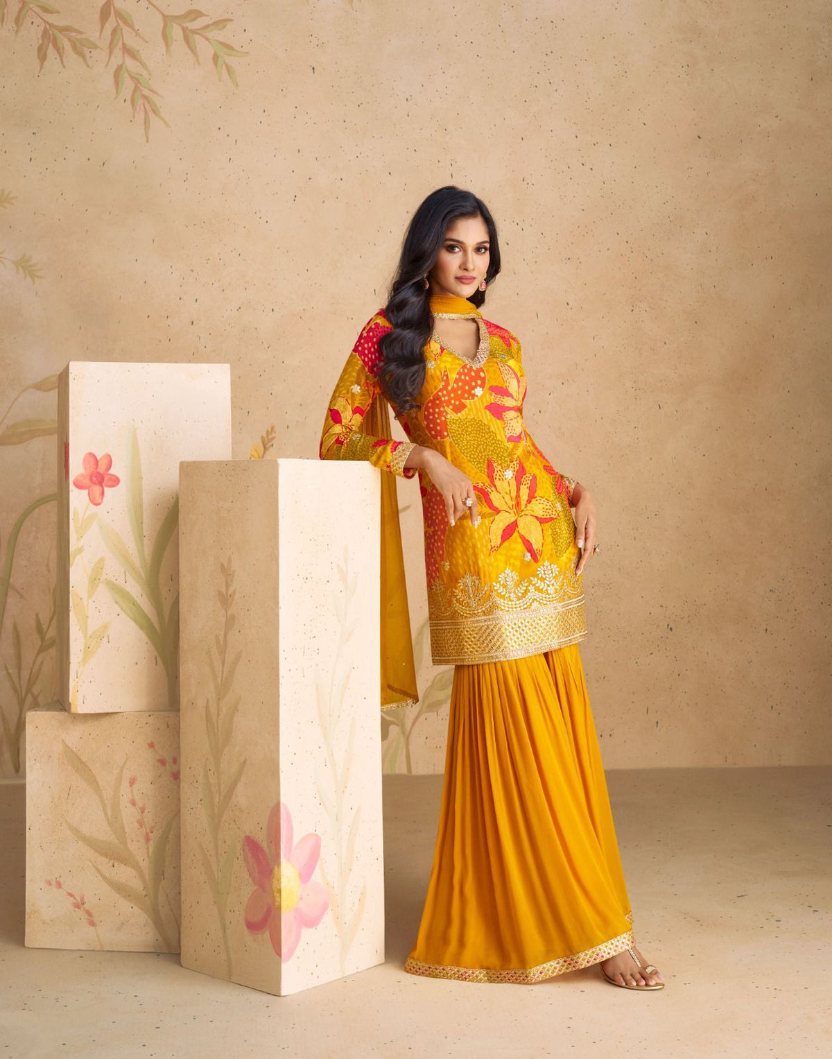 Yellow floral tunic with flared yellow trousers and drape.