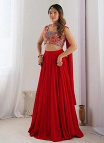 Red flared skirt and cropped sleeveless embellished top with pale drape on a model.