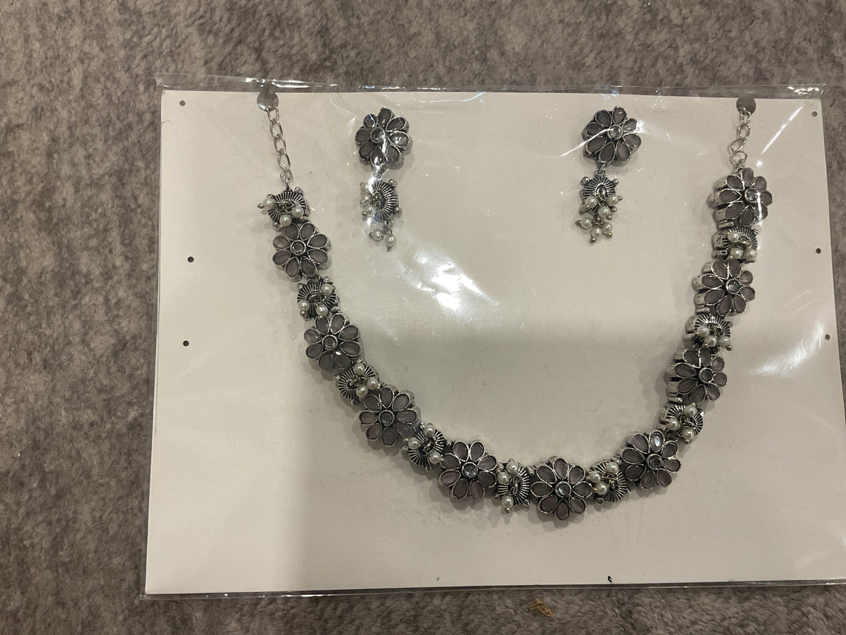 Mauve-grey necklace and earrings with silver-tone floral links, petal-shaped inserts and off-white bead clusters.