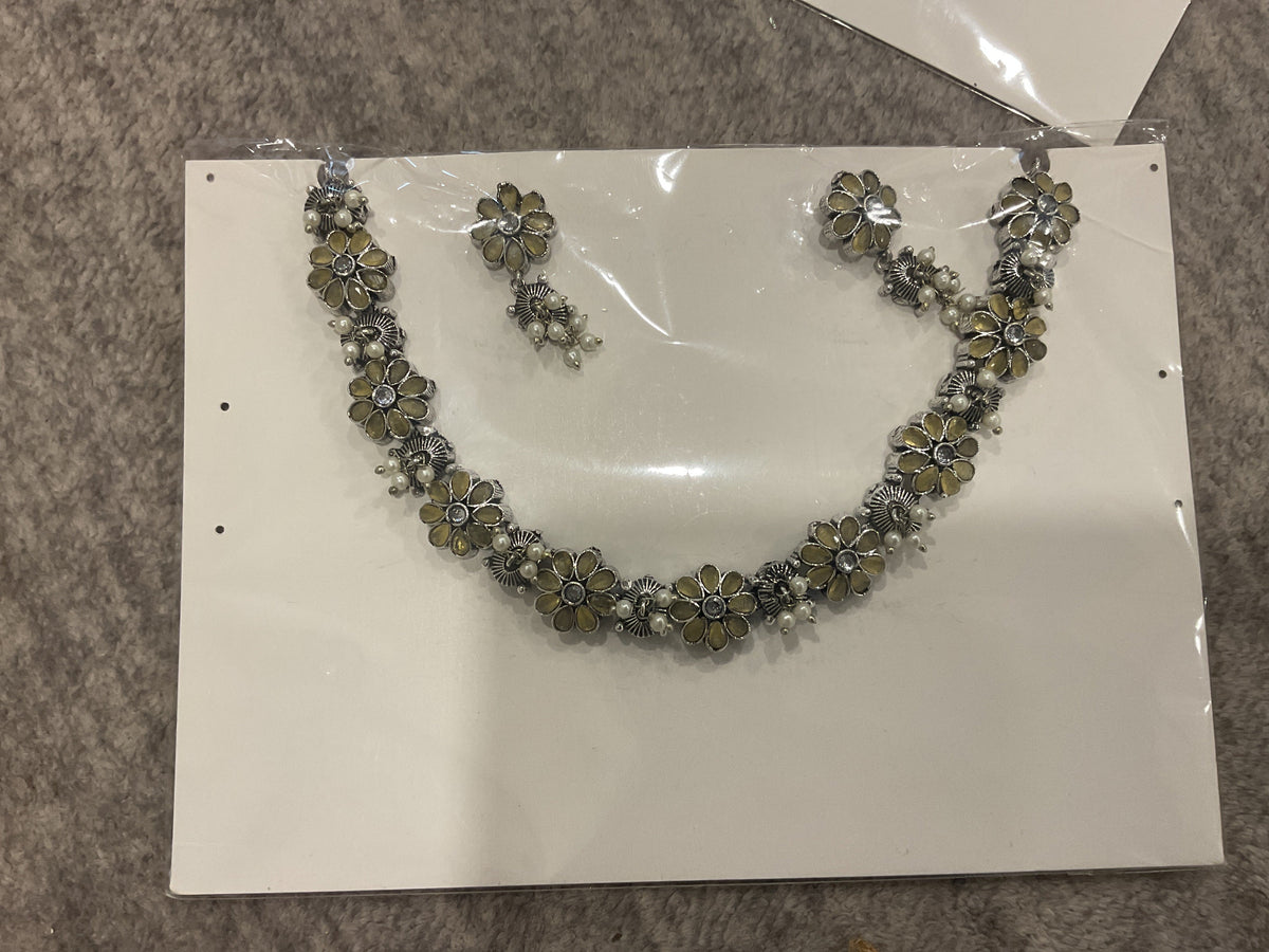Mustard-yellow necklace and earrings with silver-tone floral links, petal-shaped inserts and off-white bead clusters.