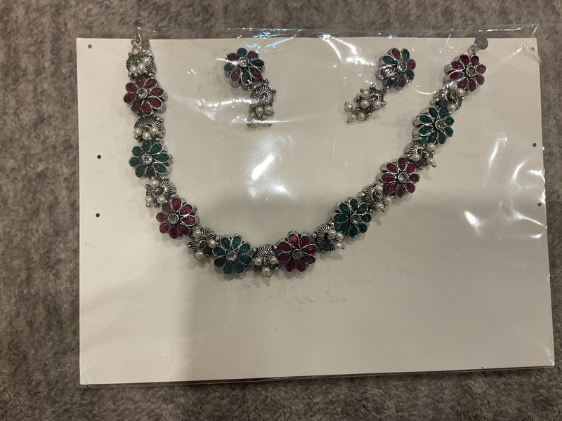 Rani-pink and green necklace and earrings with silver-tone floral links, petal-shaped inserts and off-white bead clusters.