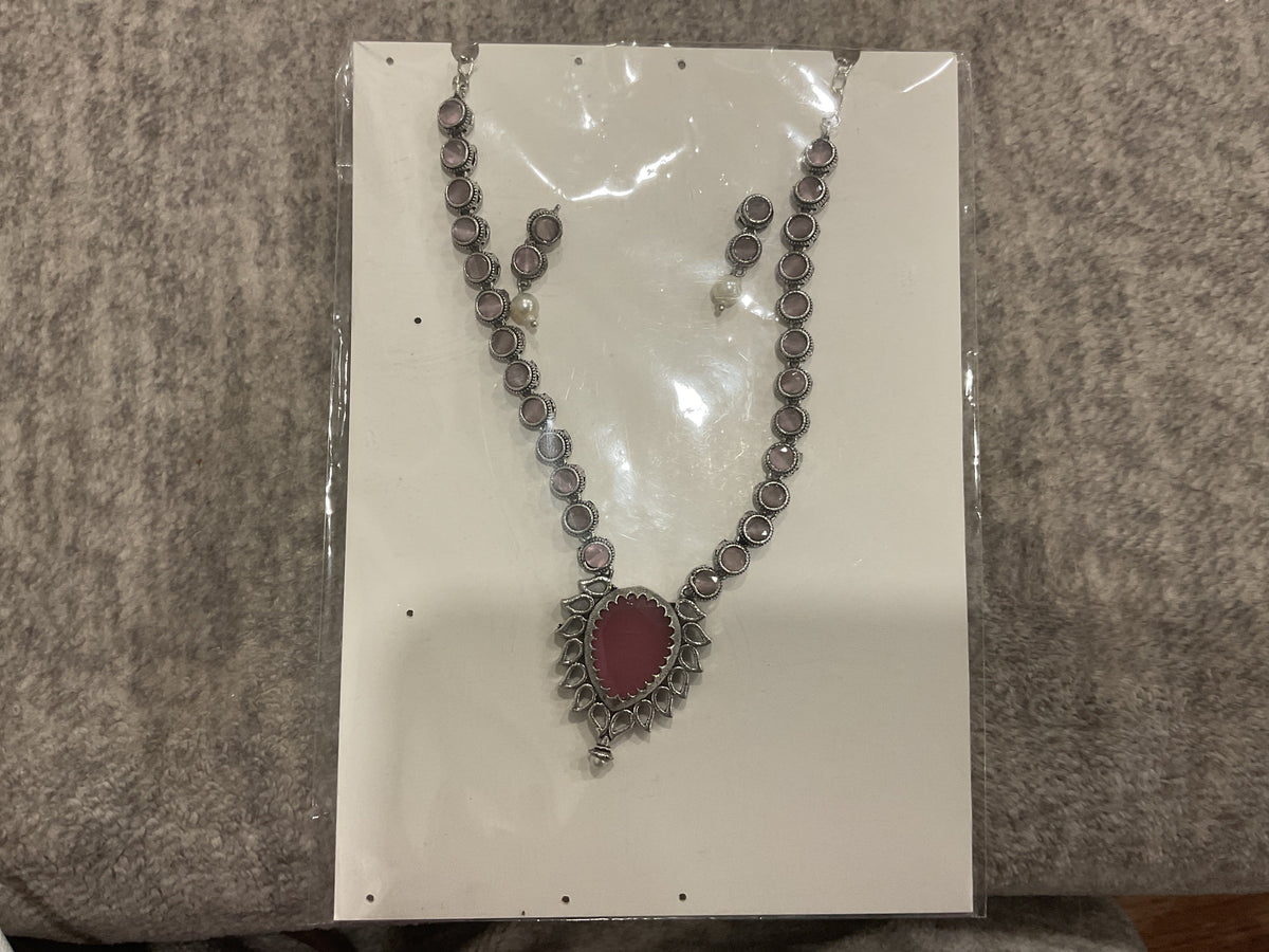 Dusty-pink necklace with round silver-tone links, a pink teardrop pendant and matching earrings.