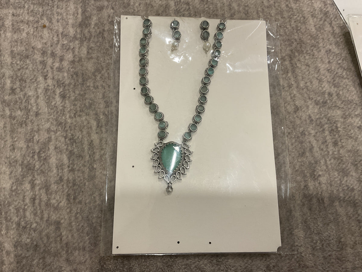 Mint-green necklace with round silver-tone links, a green teardrop pendant and matching earrings.