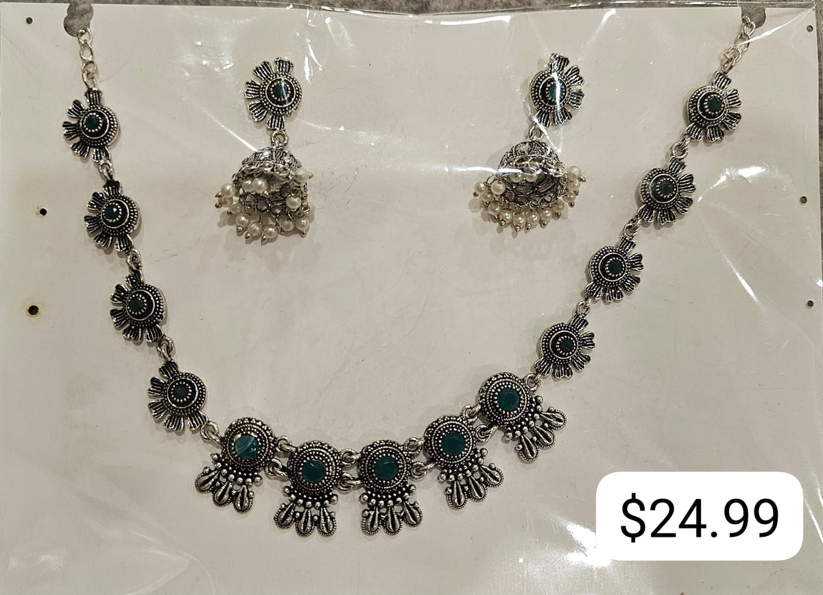 Green necklace with silver-tone round floral links, larger decorative lower motifs and bell-shaped earrings with off-white beads.