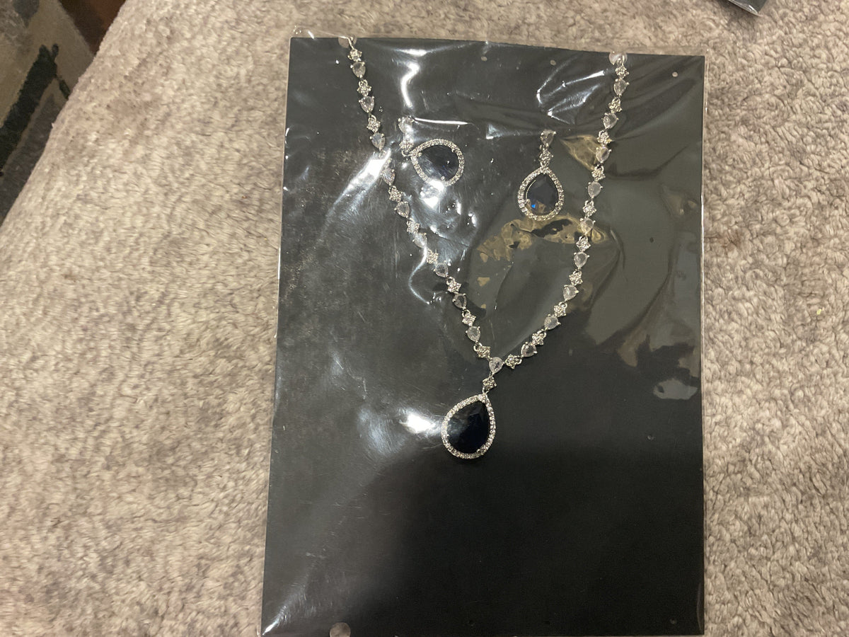 Navy-blue teardrop pendant necklace with silver-tone links, clear accents and matching photographed teardrop earrings.
