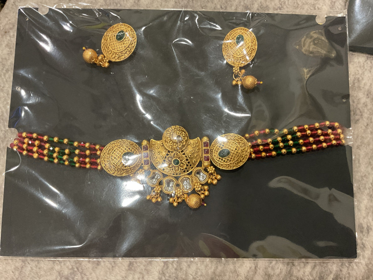 Gold-tone medallion choker with maroon and green bead strands, ornate round details, hanging gold-tone beads and matching photographed earrings.