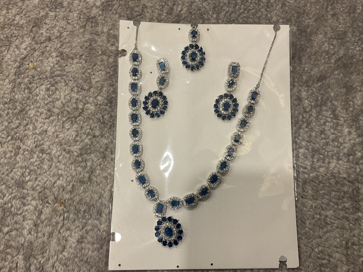 Navy-blue necklace with rectangular and oval accents, an oval sunburst pendant, drop earrings and a photographed forehead ornament.