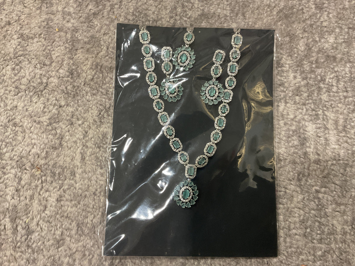 Mint-green necklace with rectangular and oval accents, an oval sunburst pendant, drop earrings and a photographed forehead ornament.