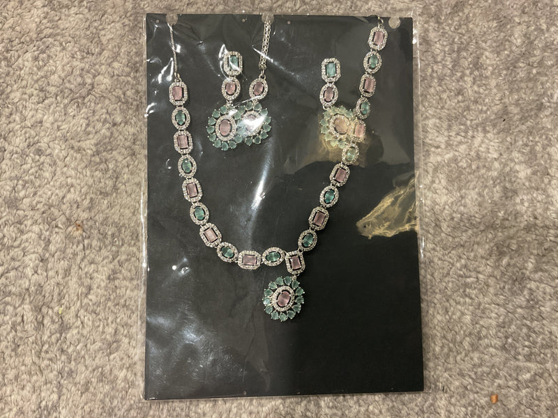 Baby-pink and mint-green necklace with rectangular and oval accents, an oval sunburst pendant, earrings and a photographed forehead ornament.