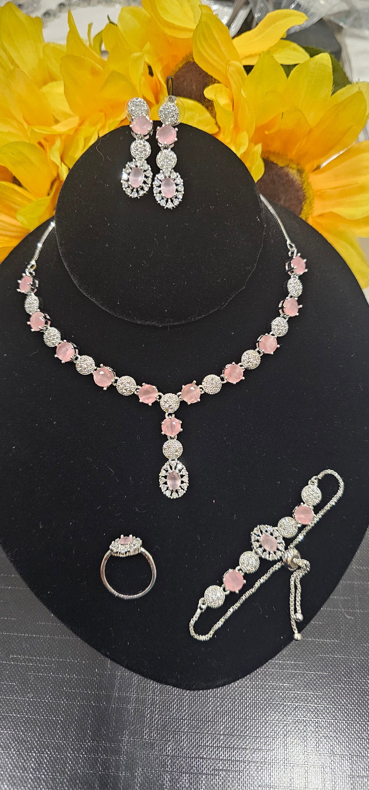 PINK necklace with alternating colored centers and clear clusters with a central drop, shown with coordinating jewelry.