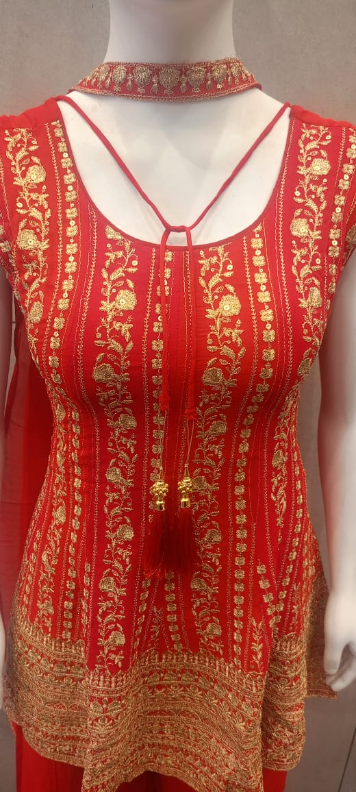 Red kurta with gold-tone floral motifs, neckline ties and a broad patterned hem, displayed on a mannequin.