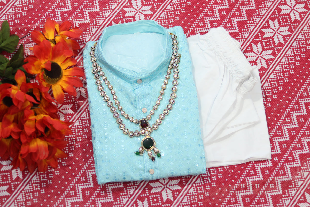 Folded sky blue kurta with repeating motifs, a band collar and front buttons, arranged beside white fabric and decorative flowers.