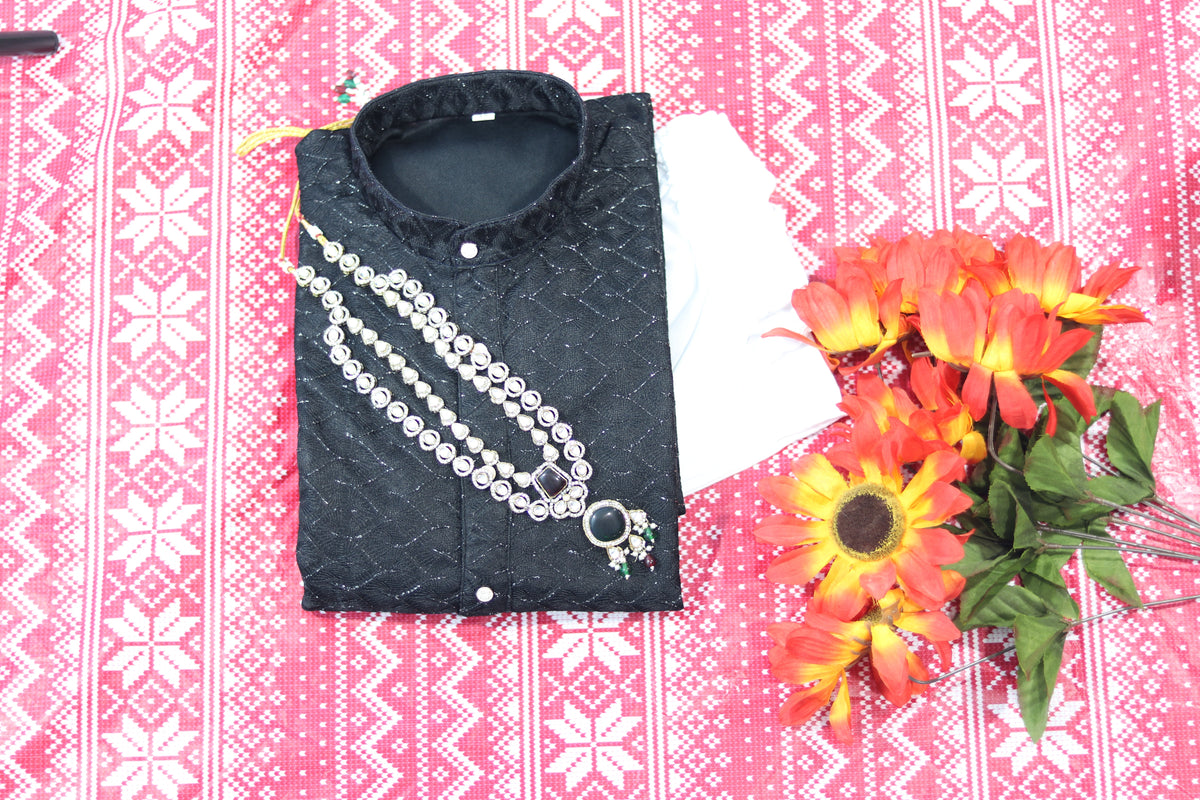 Folded black kurta with fine diamond lines, a band collar and front buttons, arranged beside white fabric and decorative flowers.