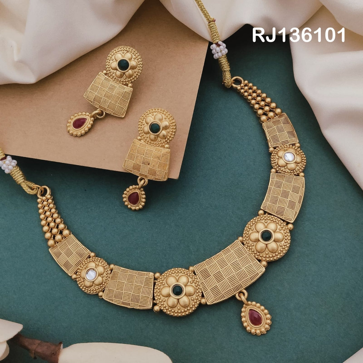 Antique gold-tone necklace with woven-look square panels alternating with round flower motifs and colored accents, shown with coordinating drop earrings.