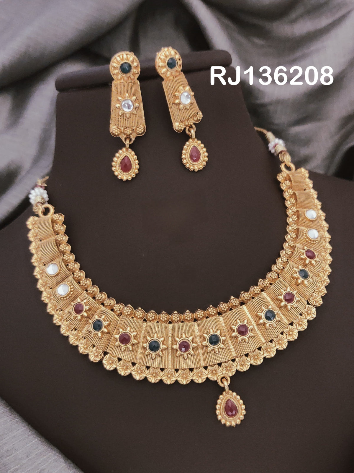Antique gold-tone necklace with textured rectangular panels, red, green and white accents and a scalloped edge, shown with coordinating drop earrings.