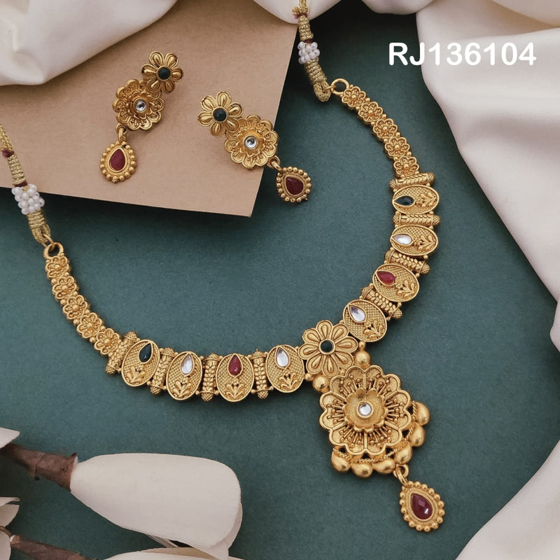 Antique gold-tone necklace with oval patterned links, a large floral pendant and a red teardrop accent, shown with coordinating drop earrings.